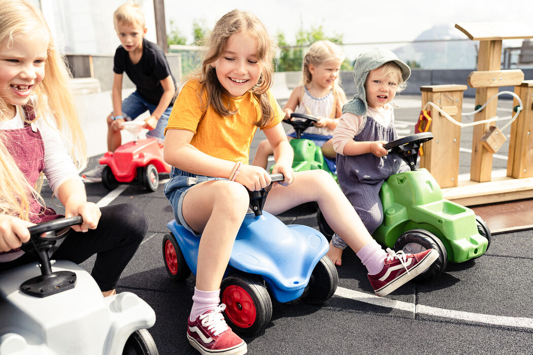 Bobbycar fahren mit den Urlaubsfreunden im Kinderhotel Allgäuer Berghof