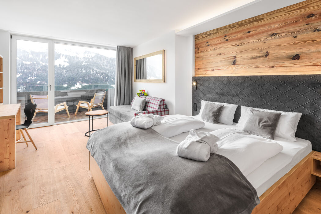 Kinderhotel Allgäuer Berghof – Wohnzimmer der Familien-Suite Hochgrat mit Blick auf die Allgäuer Alpen